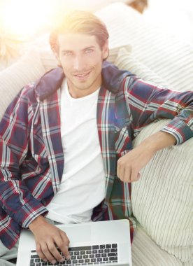 dizüstü bilgisayarda çalışan ve kameraya bakarak başarılı adam. Yukarıdan görüntülemek