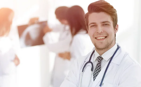 Joven doctor en el fondo de colegas —  Fotos de Stock