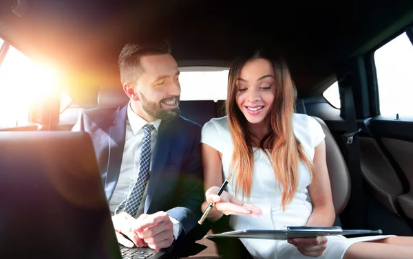 Man and woman discussing work documents in taxi — Stock Photo, Image
