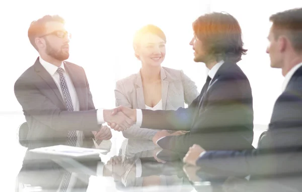 Detrás del apretón de manos glass.handshake de los socios comerciales — Foto de Stock