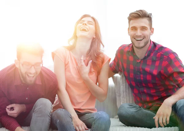 Group of young people laughing and sitting on the couch — Stock Photo, Image