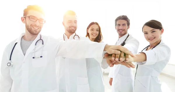 Artsen en verpleegkundigen in een medisch team stapelen handen — Stockfoto