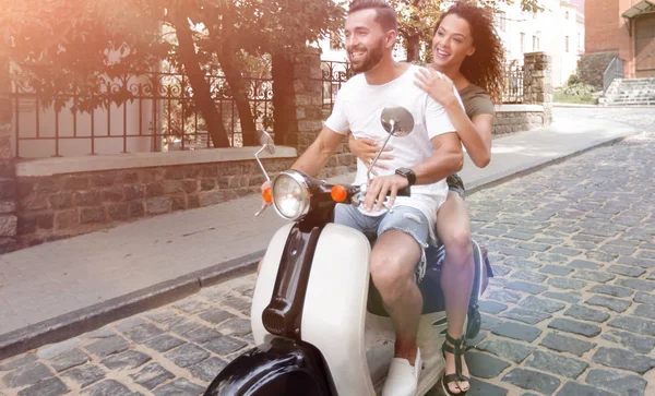 Elegante pareja joven se sienta un scooter en la calle . — Foto de Stock