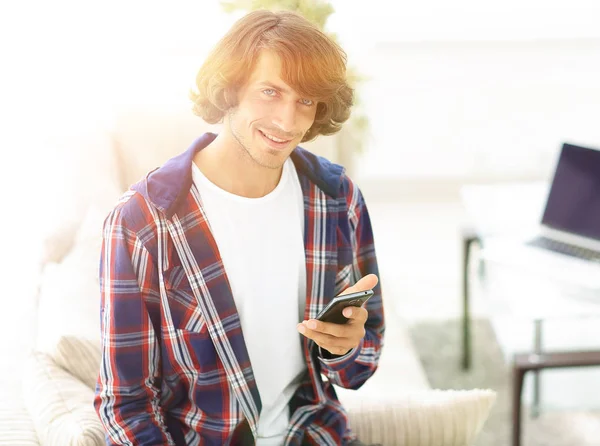 modern guy with a smartphone on a blurry background.