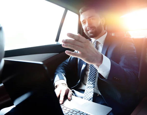 Hombre de negocios sentado en el asiento trasero en el coche y apuntando con el dedo hacia adelante — Foto de Stock