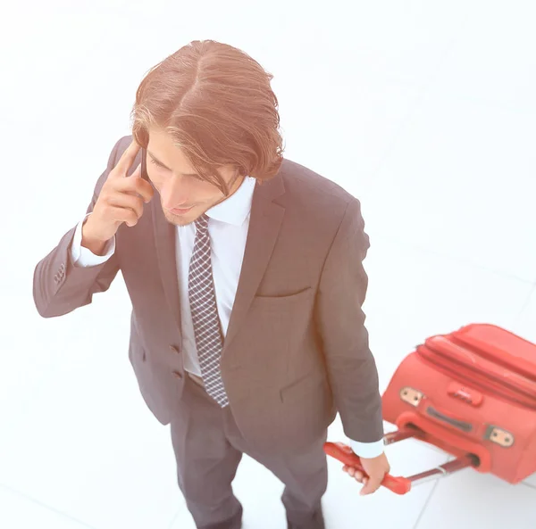 Homem de negócios com mala de viagem falando ao telefone . — Fotografia de Stock