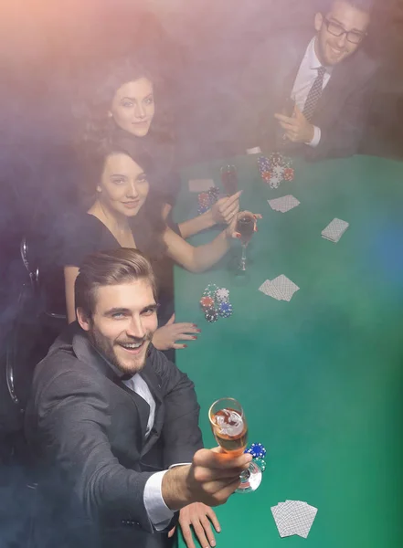 Skupina přátel, sedí u stolu kasino — Stock fotografie