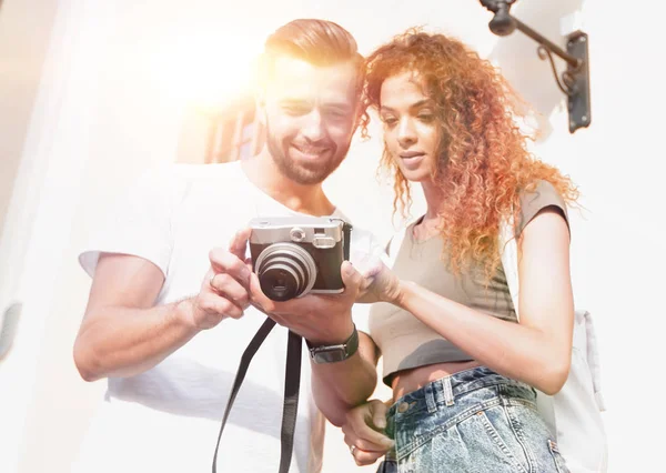 Retrato de jovens amigos andando olhando para as fotos — Fotografia de Stock