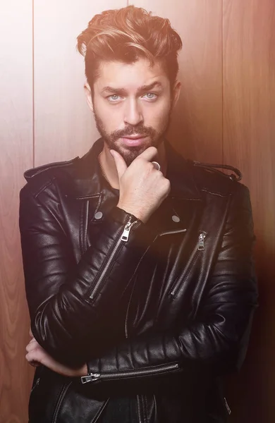 man fashion in leather jacket, wooden background