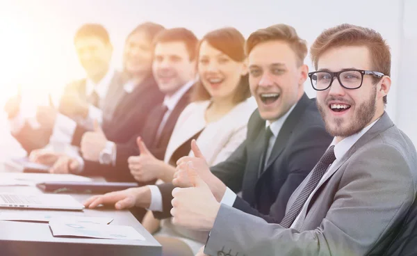 Business-team med tummen upp medan du sitter vid sitt skrivbord — Stockfoto
