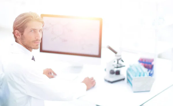 Retrato de un científico masculino con un monitor mirando al camer — Foto de Stock