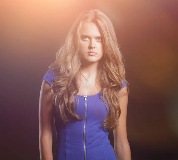 Beautiful woman in a blue dress posing on a black background — Stock Photo, Image