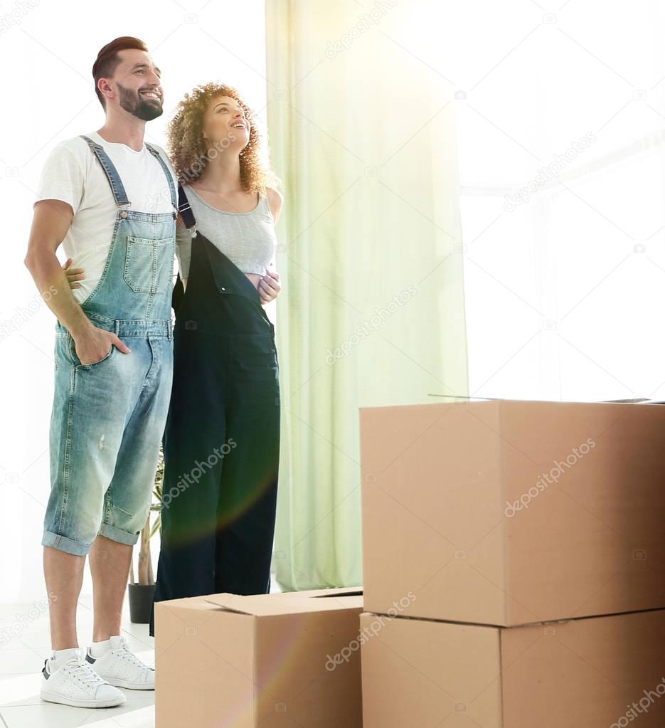 Happy young couple standing in new apartment