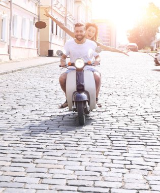 mutlu genç bir çift bir scooter üzerinde eğleniyor