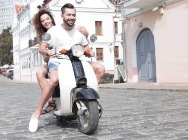 mutlu genç bir çift bir scooter üzerinde eğleniyor