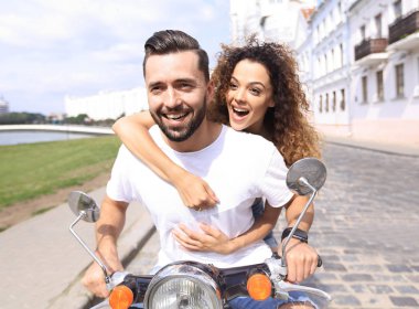 Mutlu çift sürme vintage scooter açık havada.