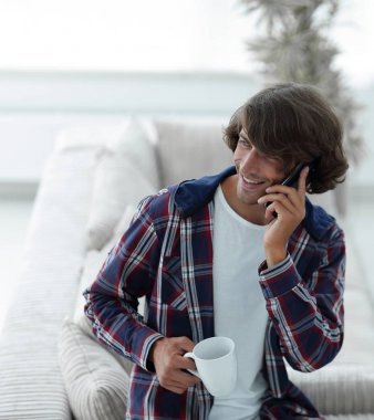 güzel bir fincan adamla bir dizüstü bilgisayar önünde oturur.