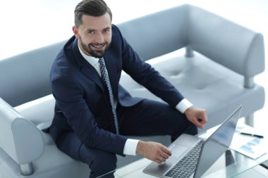 mali grafikler ile bir dizüstü bilgisayar üzerinde çalışan iş adamı