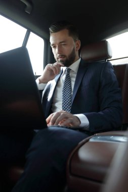 laptop ile çalışan ve bir araba pencereden dışarı bakarak işadamı