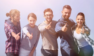 başparmak gösterilmesini gençlerin grup gülümseyen.