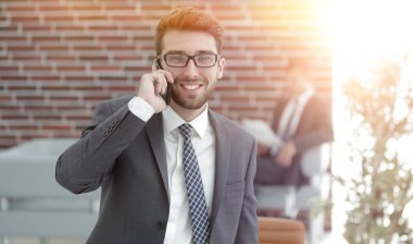 ofisinde smartphone cep telefonu ile konuşurken işadamı