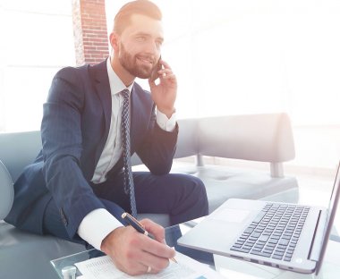 İşadamı Smartphone'da finansal belgeler hakkında konuşmak