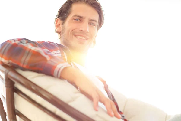 Close-up van een glimlachende man zijn hond aaien zittend in een grote fauteuil. — Stockfoto