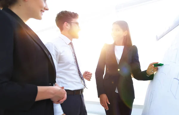 Business woman pointing with a marker on the flipchart — Stock Photo, Image