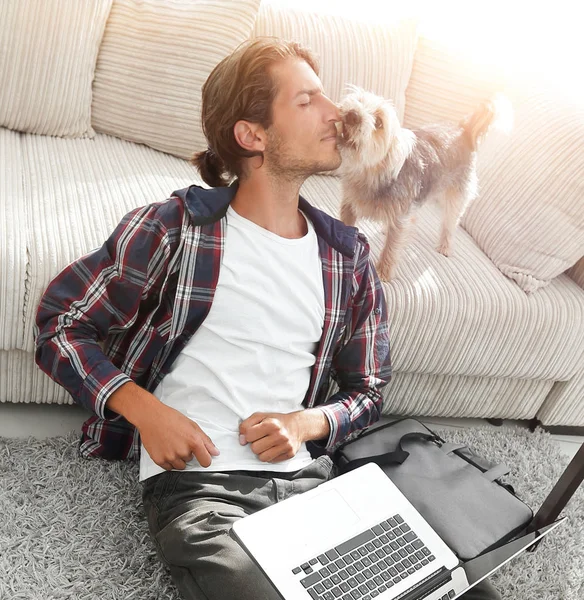 Gelukkig man met laptop jubelende in ruime woonkamer. — Stockfoto