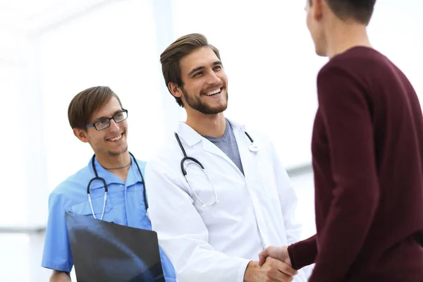 Médico sorrindo apertando a mão de um paciente — Fotografia de Stock