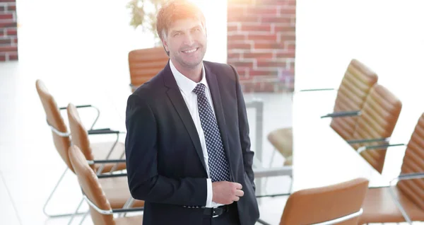 Homem de negócios de pé em uma sala de reuniões vazia — Fotografia de Stock