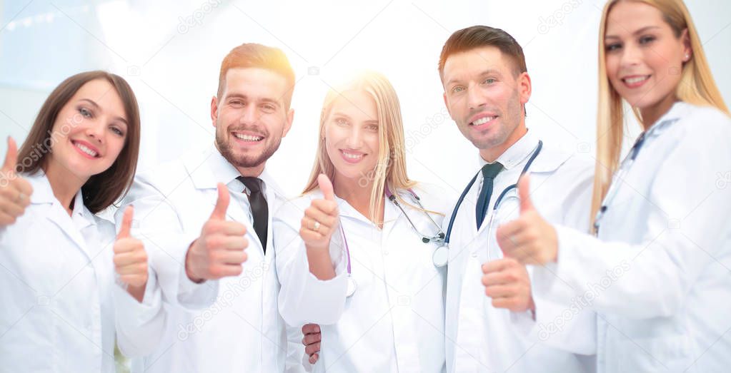 Portrait of a doctor and medical team showing thumb up