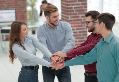 Bir grup insan, ortaklık takım çalışması için el ele tutuşuyor..
