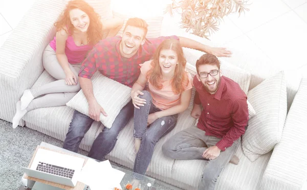 Blick von oben. Eine Gruppe lachender Freunde sitzt auf dem sof — Stockfoto