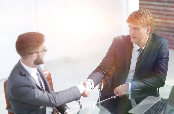 Geschäftsleute beim Händedruck am Tisch . — Stockfoto