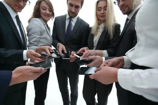 Крупный план смартфонов в руках деловой молодежи — стоковое фото