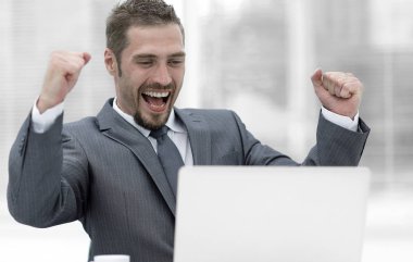 açık bir dizüstü bilgisayar önünde oturup closeup.happy iş adamı.