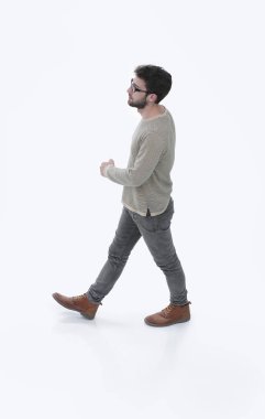yan görünümü. modern genç adam güvenle ileri gider.