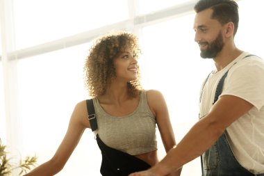 Yeni bir ev içinde bir pencere yakınında duran yeni evliler