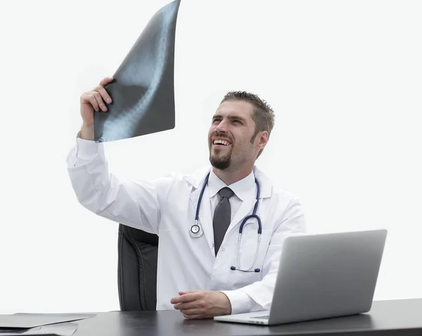 Médico examina um raio-x, sentado atrás de uma mesa — Fotografia de Stock