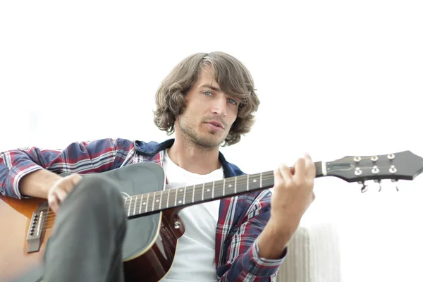 Bonito homem tocando na guitarra no sofá em casa — Fotografia de Stock