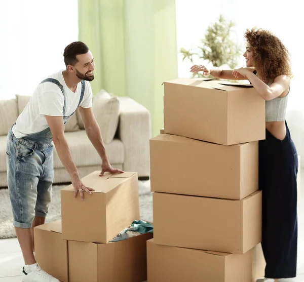 Feliz e jovem casal olhando para caixas — Fotografia de Stock