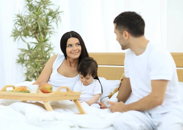 Familia tomando el desayuno en la cama en el dormitorio —  Fotos de Stock