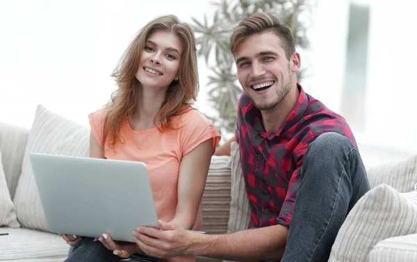 Glimlachend paar rustend thuis, zittend op de bank. — Stockfoto