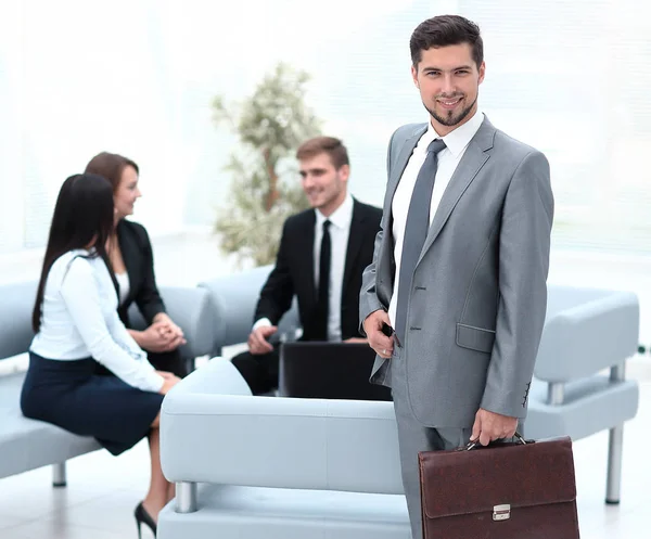 Hombre de negocios confiado con maletín de pie en el vestíbulo de la oficina . — Foto de Stock