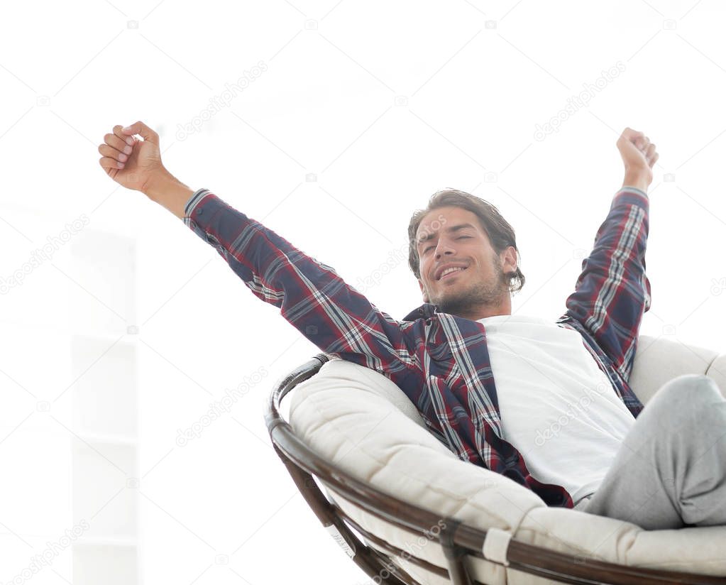 stylish guy stretching in a comfortable chair