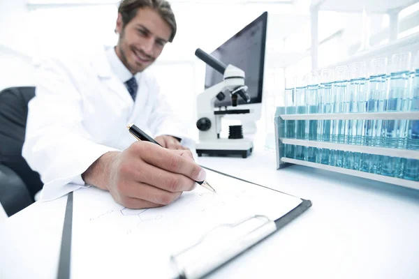 Scientist makes a note of experiment in the laboratory — Stock Photo, Image