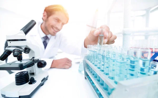 Chemist looking at test-tubes with blue liquids — Stock Photo, Image