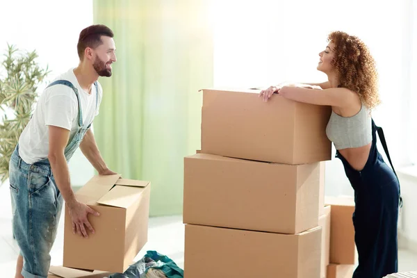 Молода пара розпаковує коробки в новому будинку — стокове фото