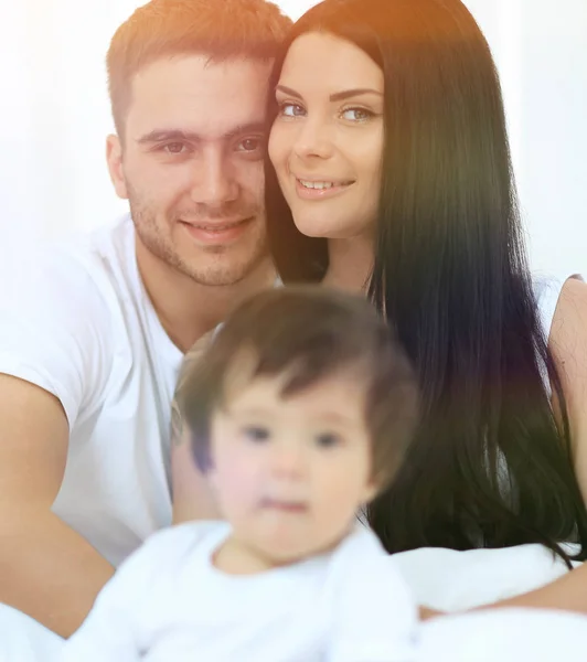 Netter kleiner Junge mit Eltern auf dem Bett — Stockfoto